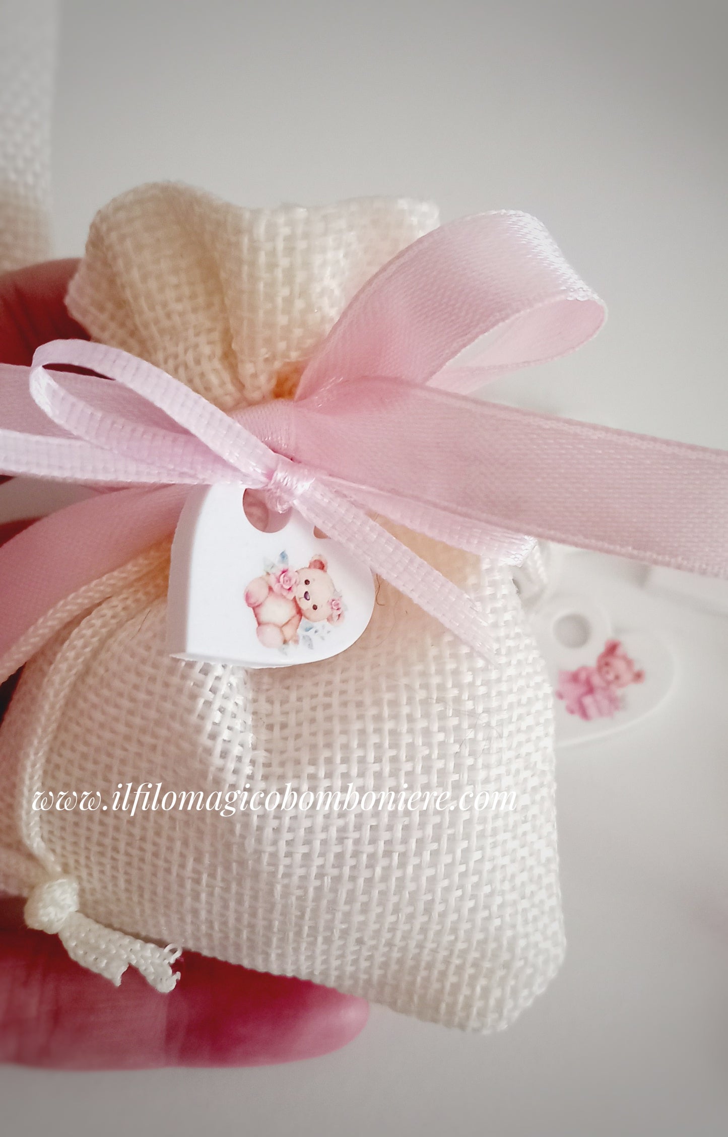 Elegante bomboniera per battesimo di una bambina, con confetti al cioccolato e un tenero cuoricino con orsetti.