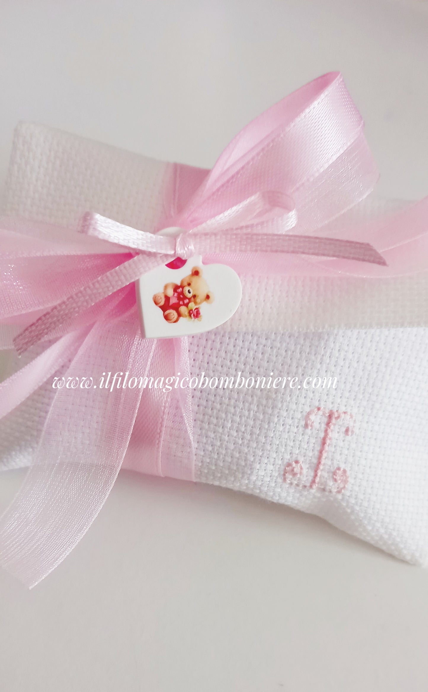 Sacchetto battesimo rosa con iniziale ricamata, perfetto per un dono raffinato agli invitati.