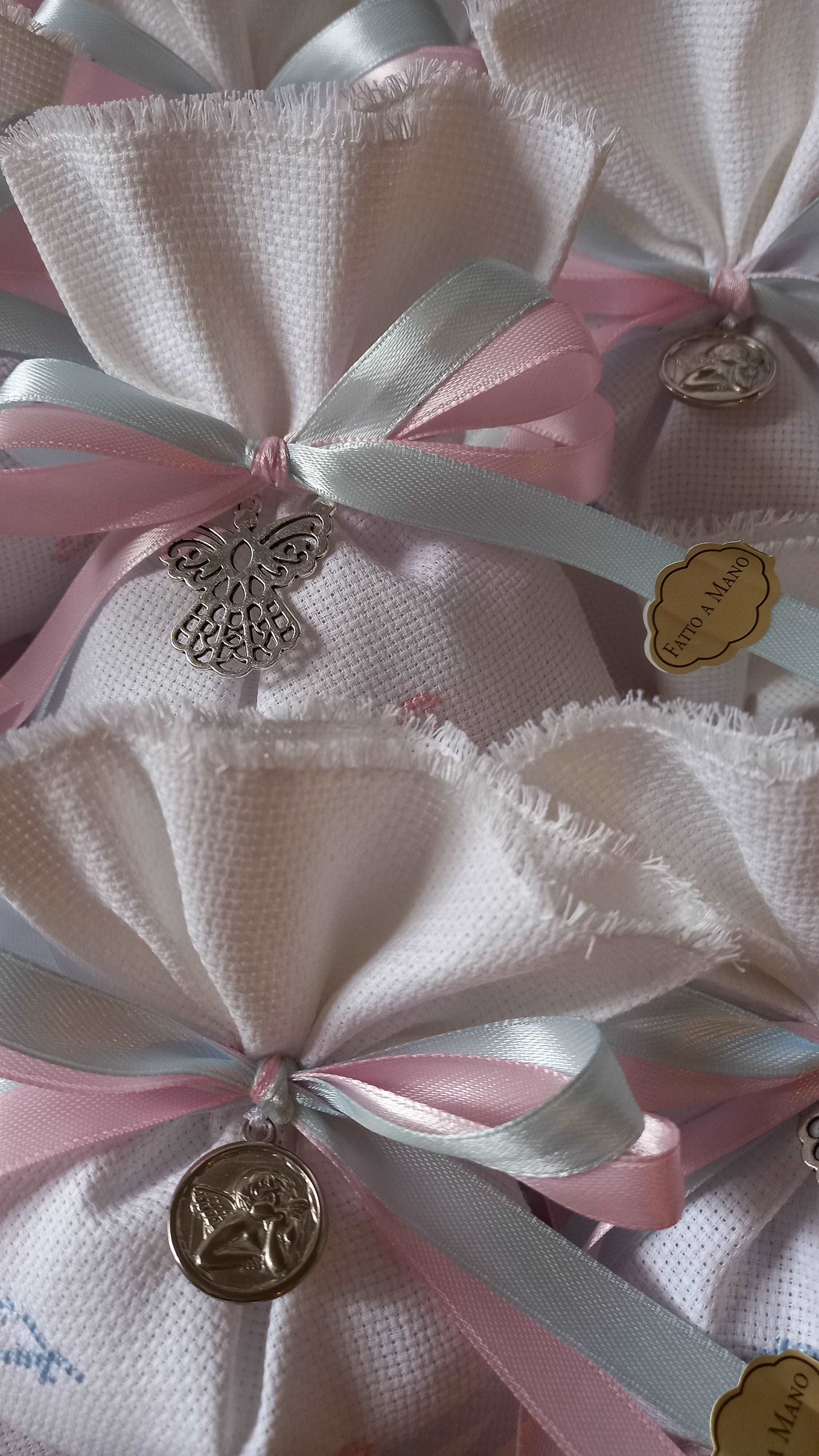 bomboniere battesimo gemelli sacchettino bianco con iniziali ricamate in rosa e azzurro con nastri raso rosa e azzurro e ciondolo medaglietta angelo