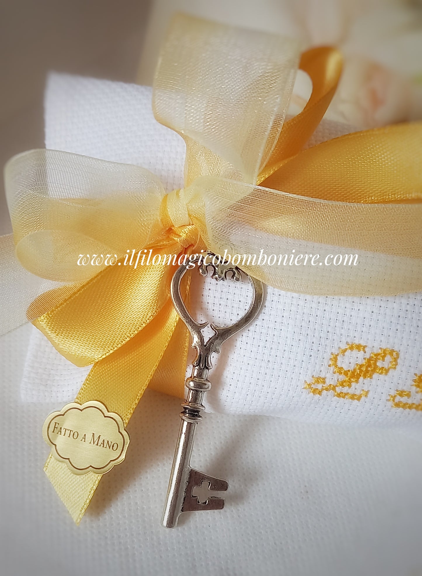 bomboniera matrimonio o nozze oro busta bianca con iniziali dei nomi ricamate a mano in color giallo oro nastri organza e raso in tinta con il ricamo ciondolo chiave e etichetta con scritta Fatto a Mano