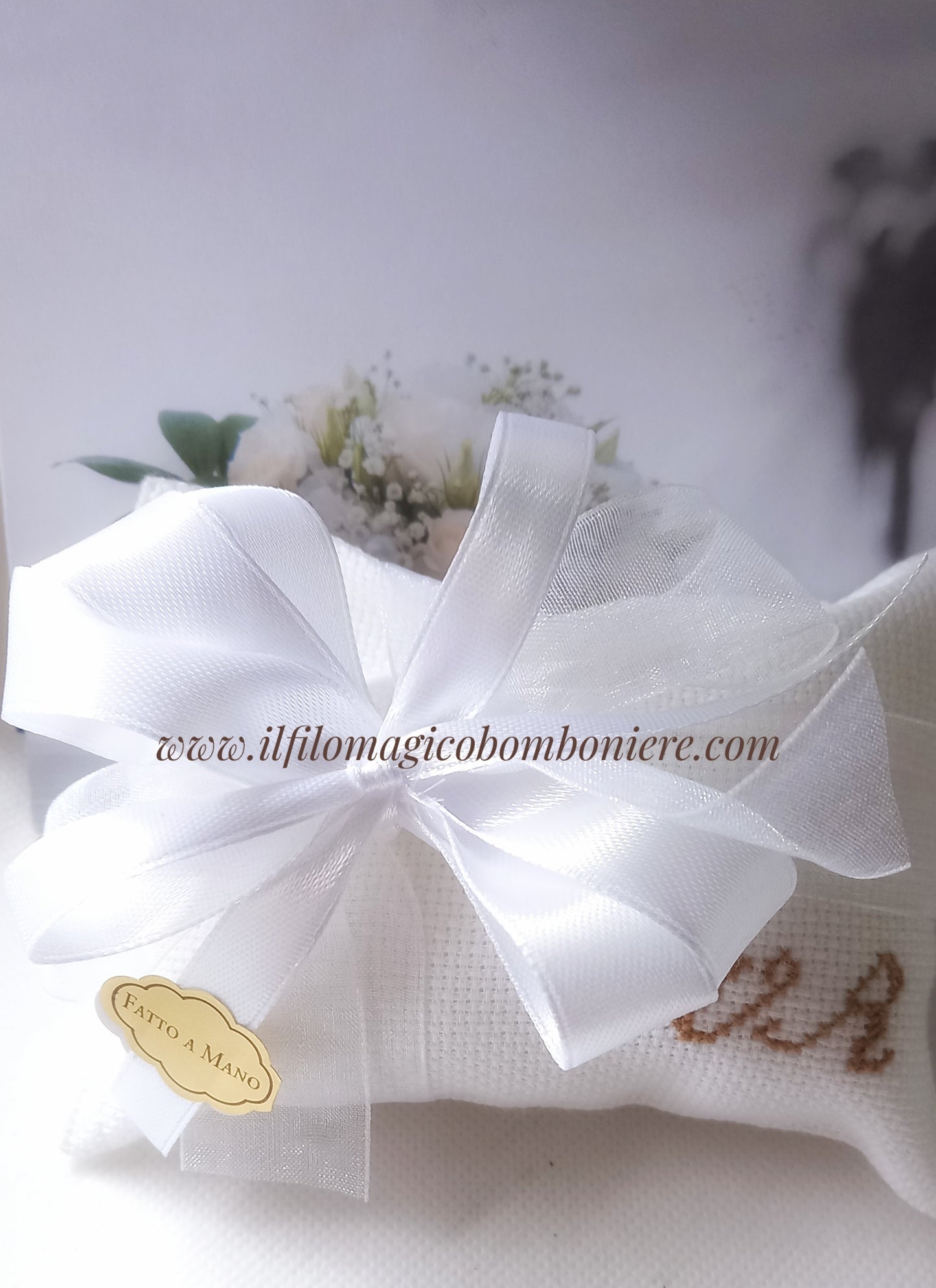 bomboniera matrimonio composta da busta bianca con iniziali ricamate in marrone nastri raso bianco e etichetta dorata con scritta fatto a mano