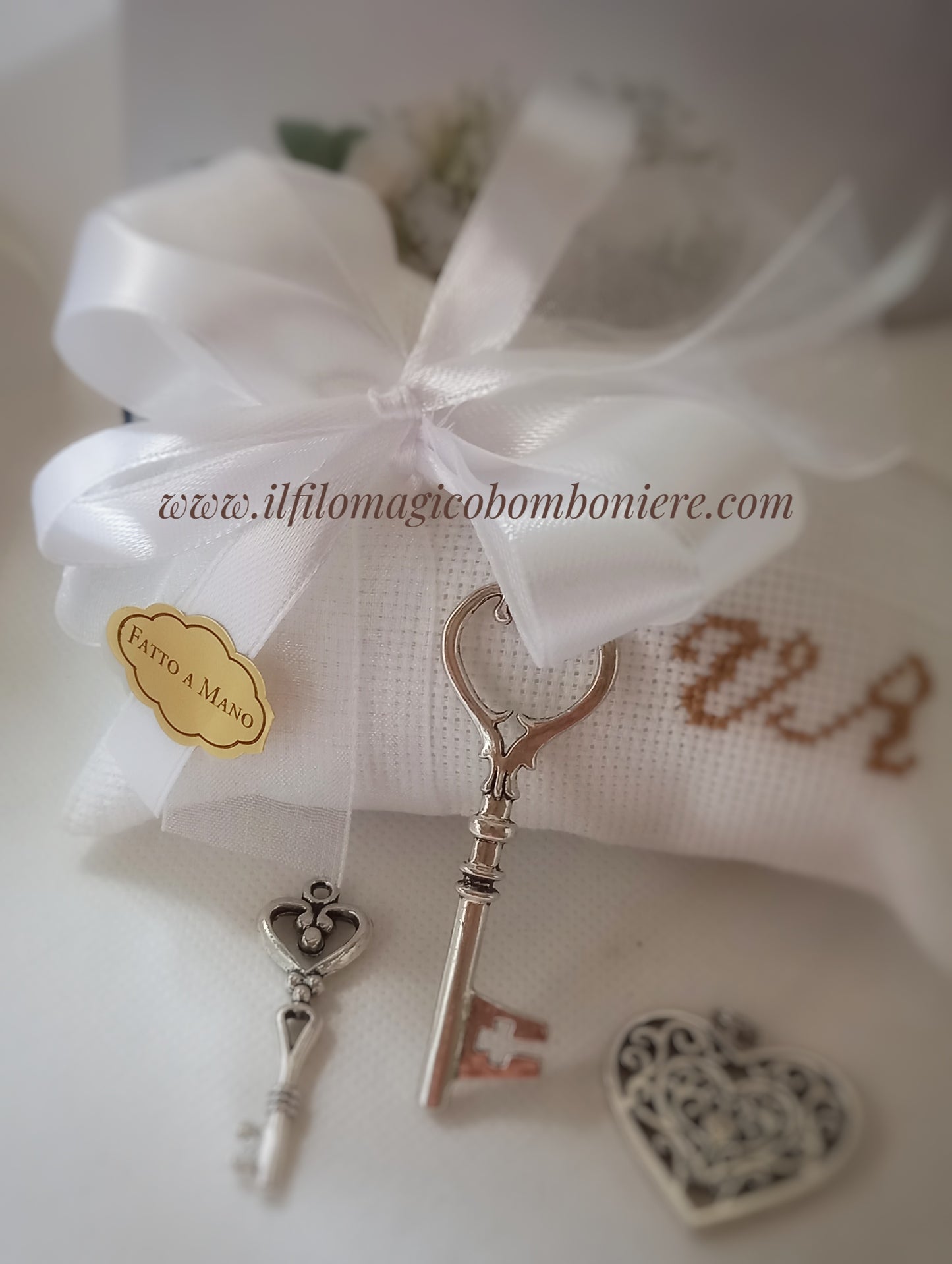 bomboniera matrimonio busta bianca con iniziali ricamate in marrone astri raso bianco ciondoli chiave e cuore