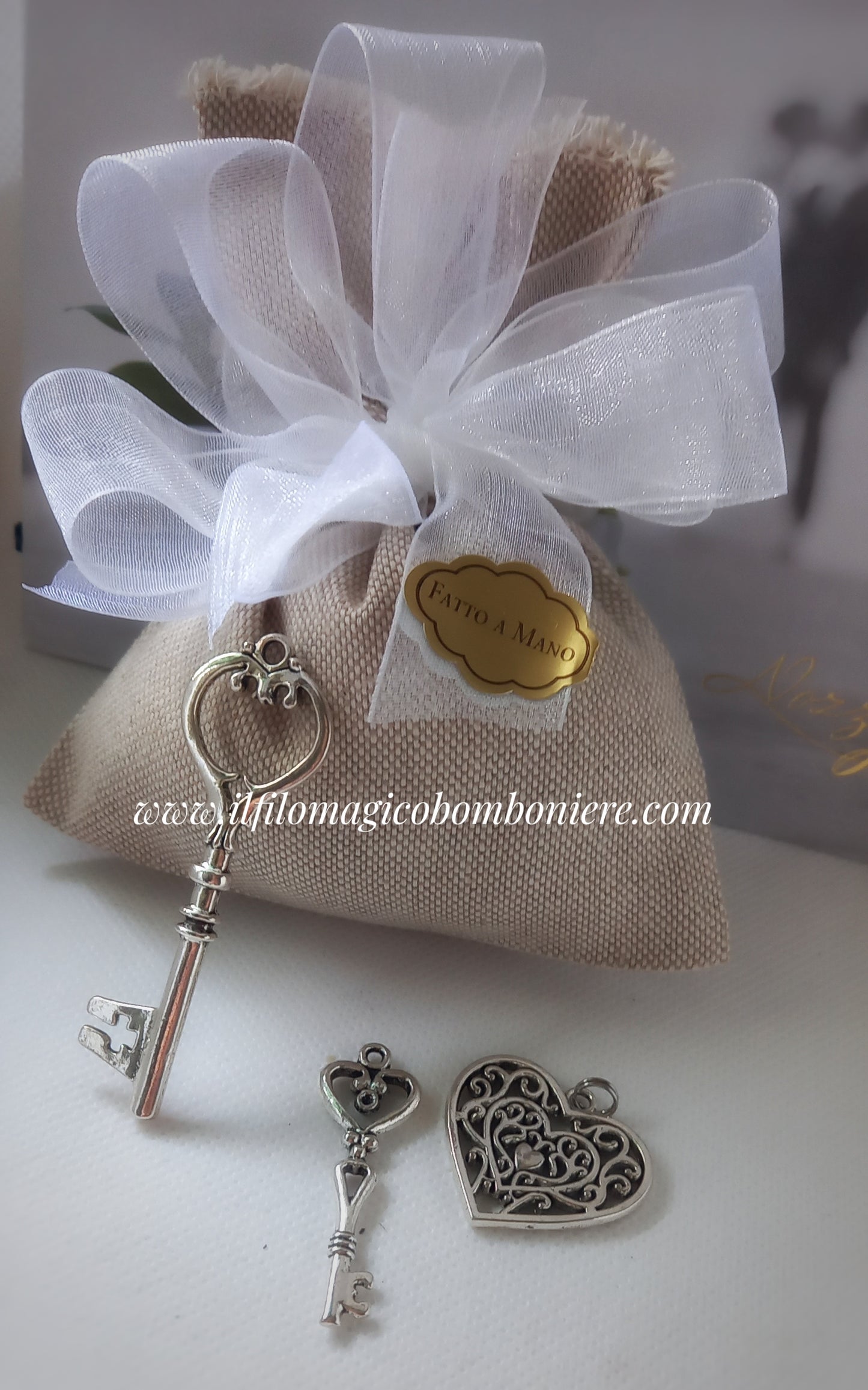 bomboniera matrimonio composta da sacchettino in lino grezzo fiocchi organza bianca e etichetta dorata con scritta fatto a mano