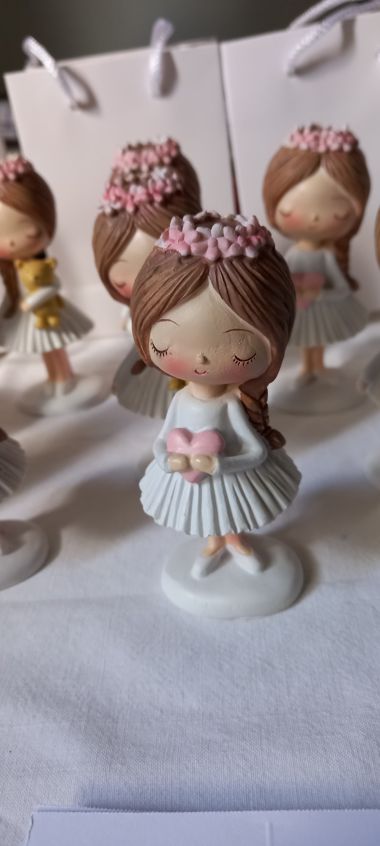Bomboniere dolci e raffinate: statuine di bambine con coroncina floreale, simbolo di purezza e tenerezza.