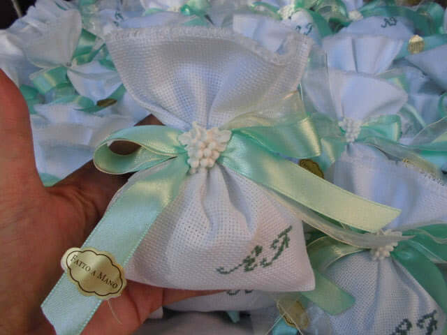 bomboniere matrimonio composte da sacchettino bianco con iniziali dei nomi degli sposi ricamate a mano in verde Tiffany e in abbinamento grappolo d'uva profuma biancheria