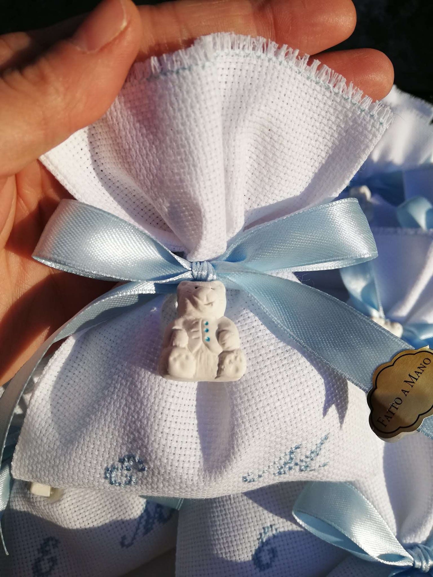 bomboniere battesimo gemelli sacchettino bianco con iniziali dei nomi ricamate in azzurro nastri raso azzurro e gessetto orsetto
