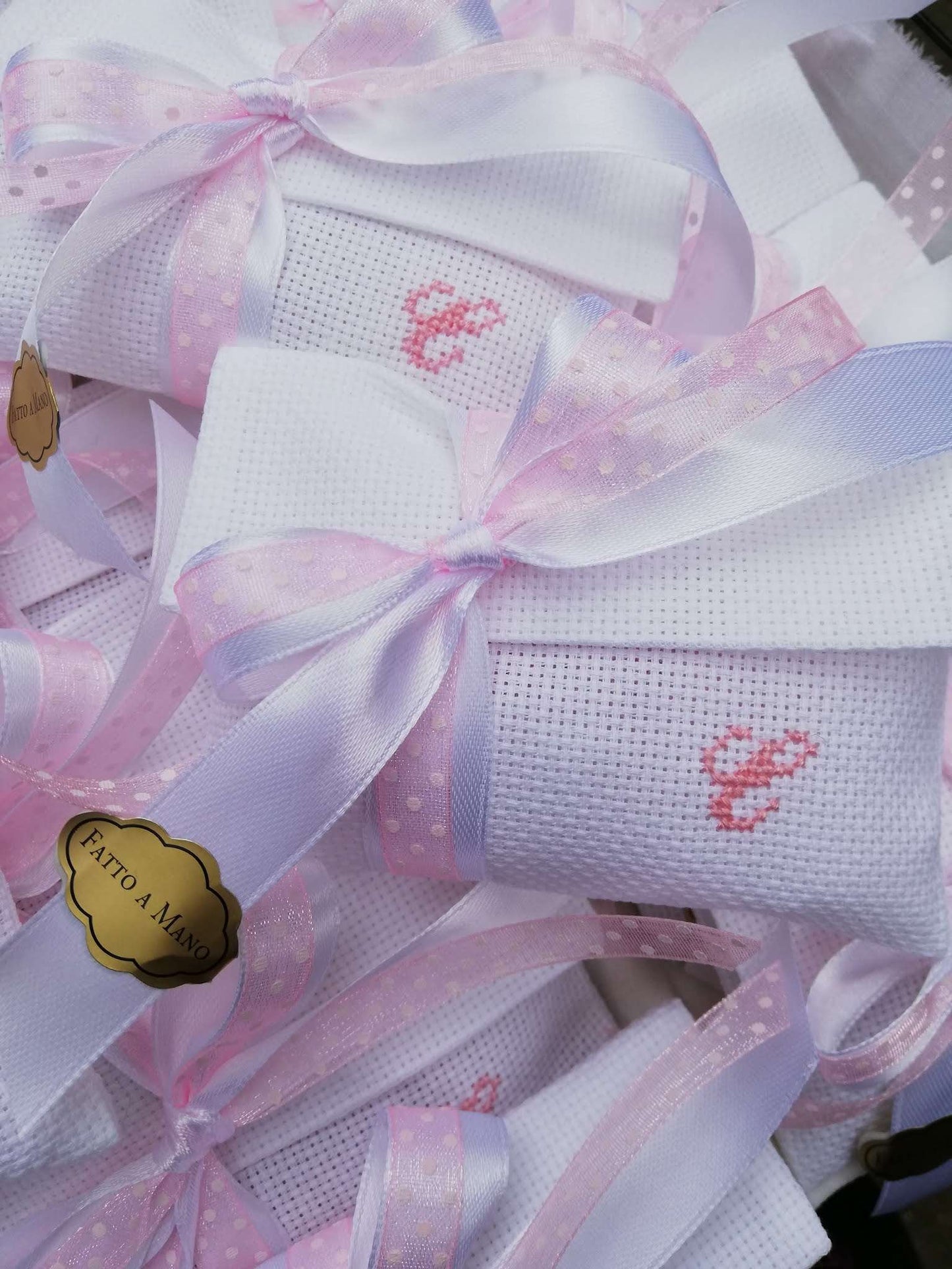 bomboniere battesimo o comunione composte da busta bianca con iniziale del nome ricamata a mano in rosa