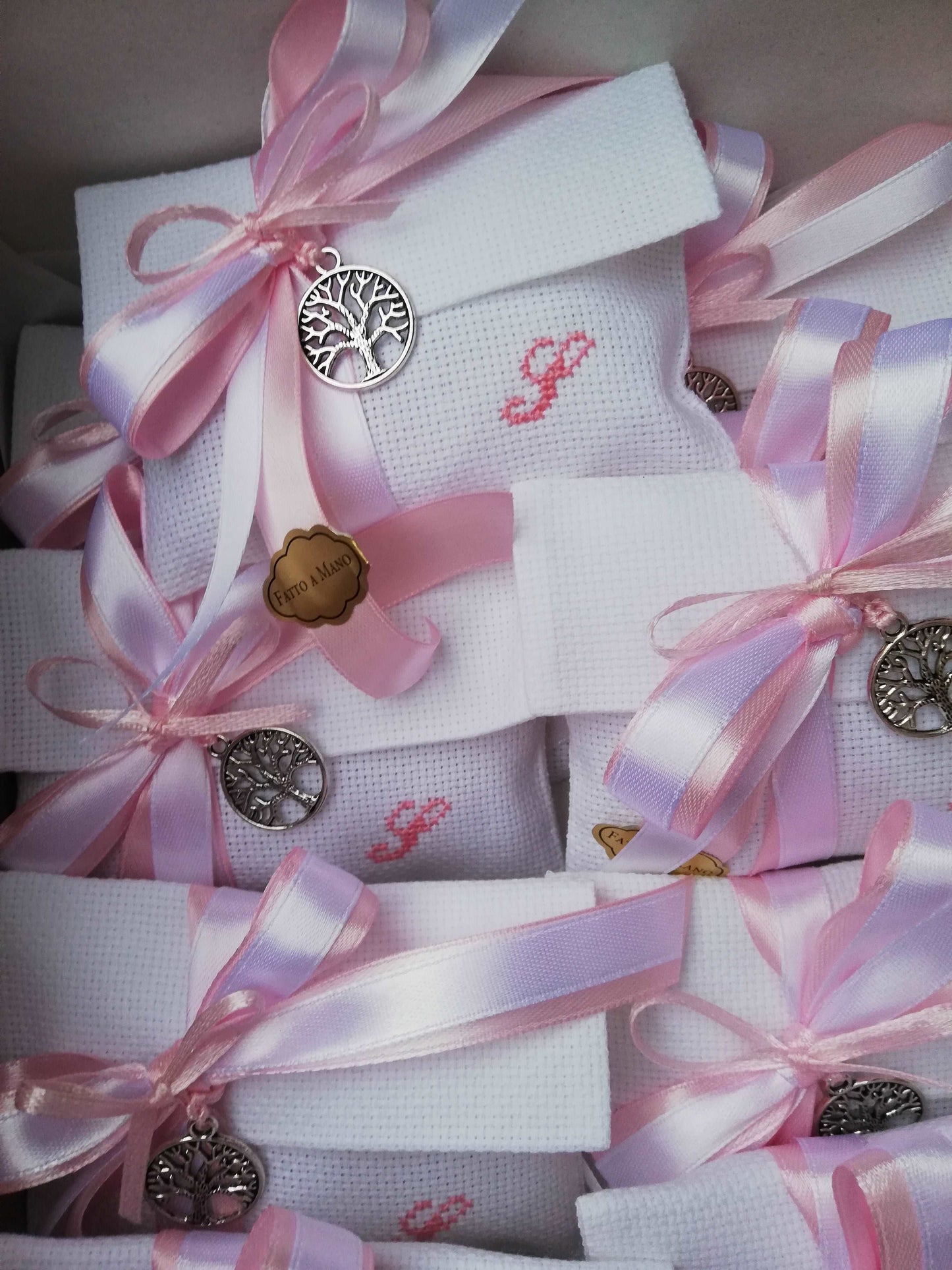 bomboniere per bimba busta bianca con iniziale del nome ricamata in rosa nastri raso rosa e bianco e ciondolo tondo albero della vita