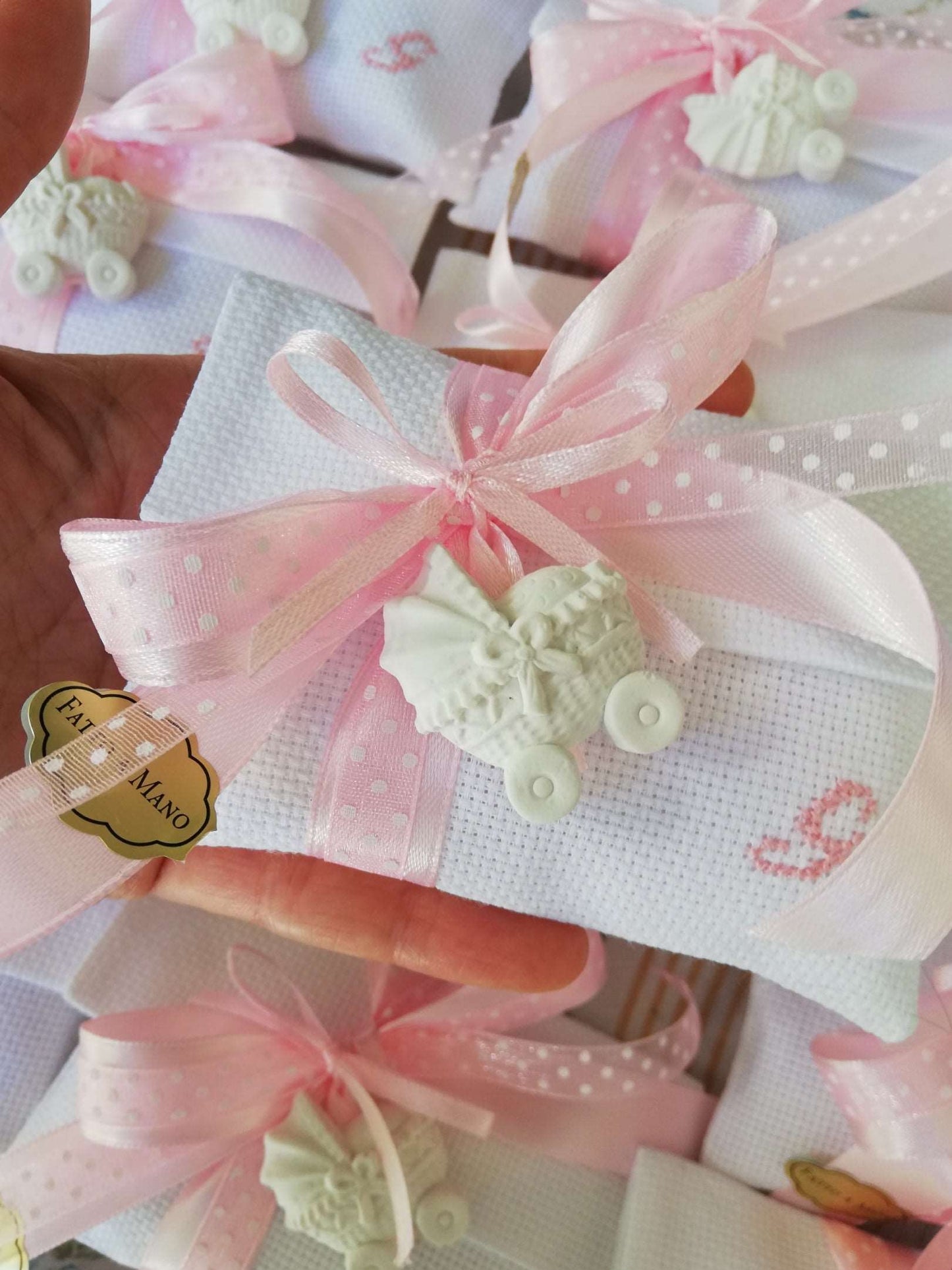 buste bianche con iniziale del nome ricamata a mano in rosa nastri raso e organza a pois entrambi rosa e carrozzina profuma biancheria