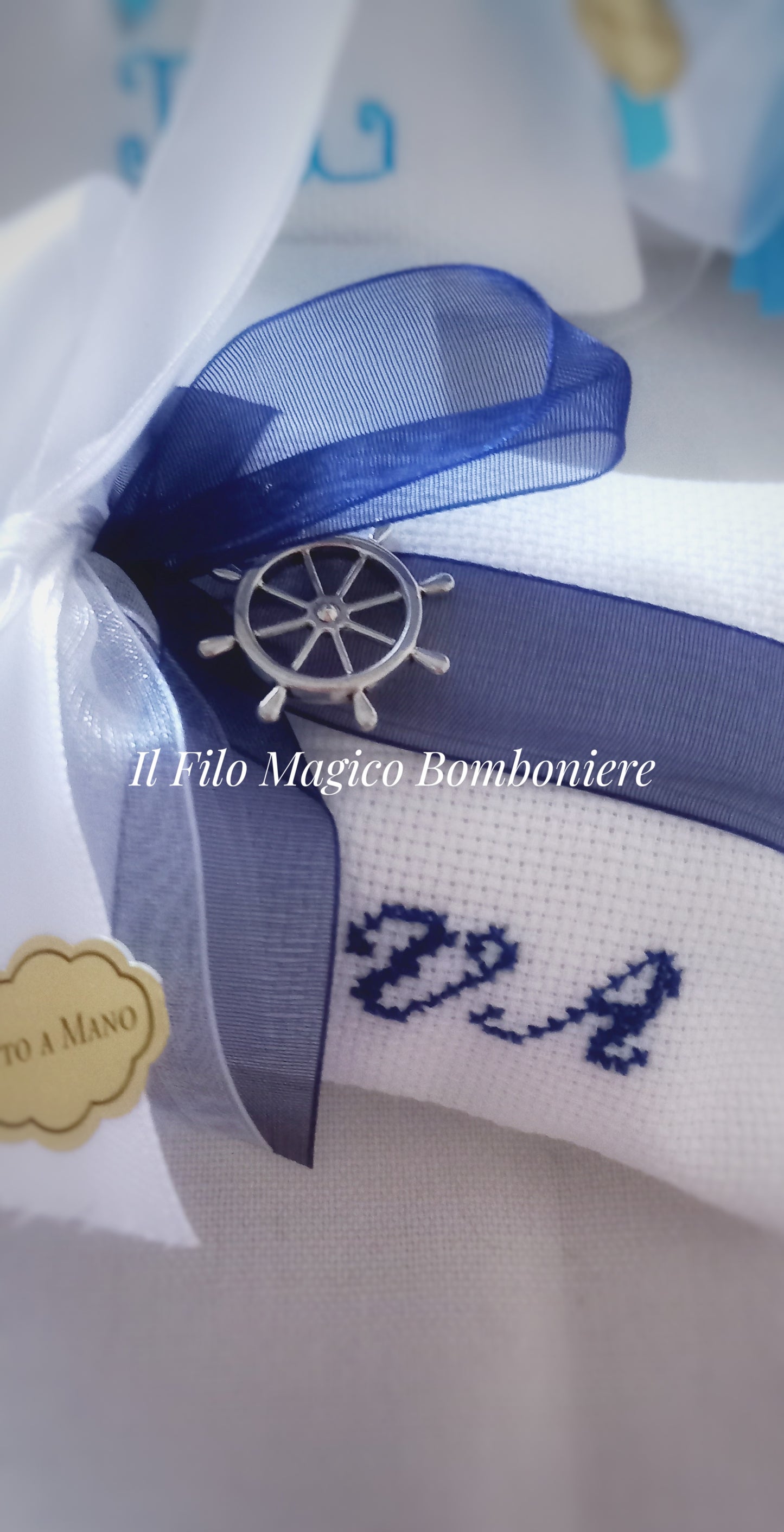 Dettaglio fiocco in organza e ciondolo a forma di timone nautico