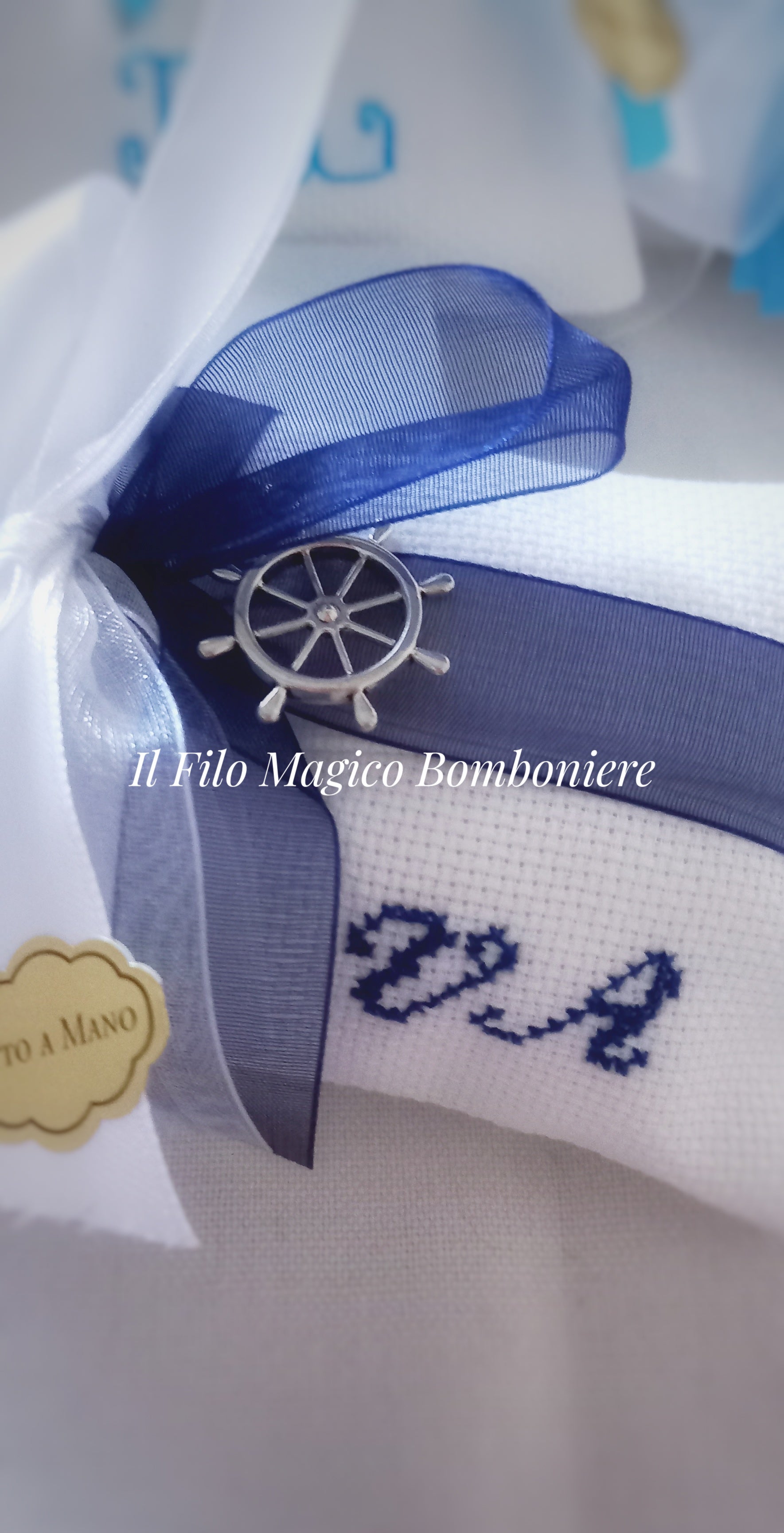Dettaglio fiocco in organza e ciondolo a forma di timone nautico