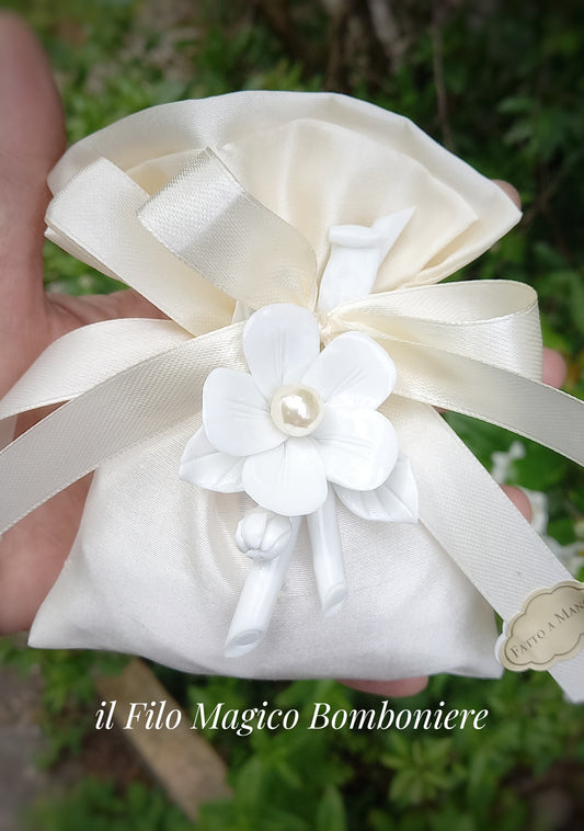 Bomboniera in shantung di seta avorio con fiore in ceramica bianca e confetti