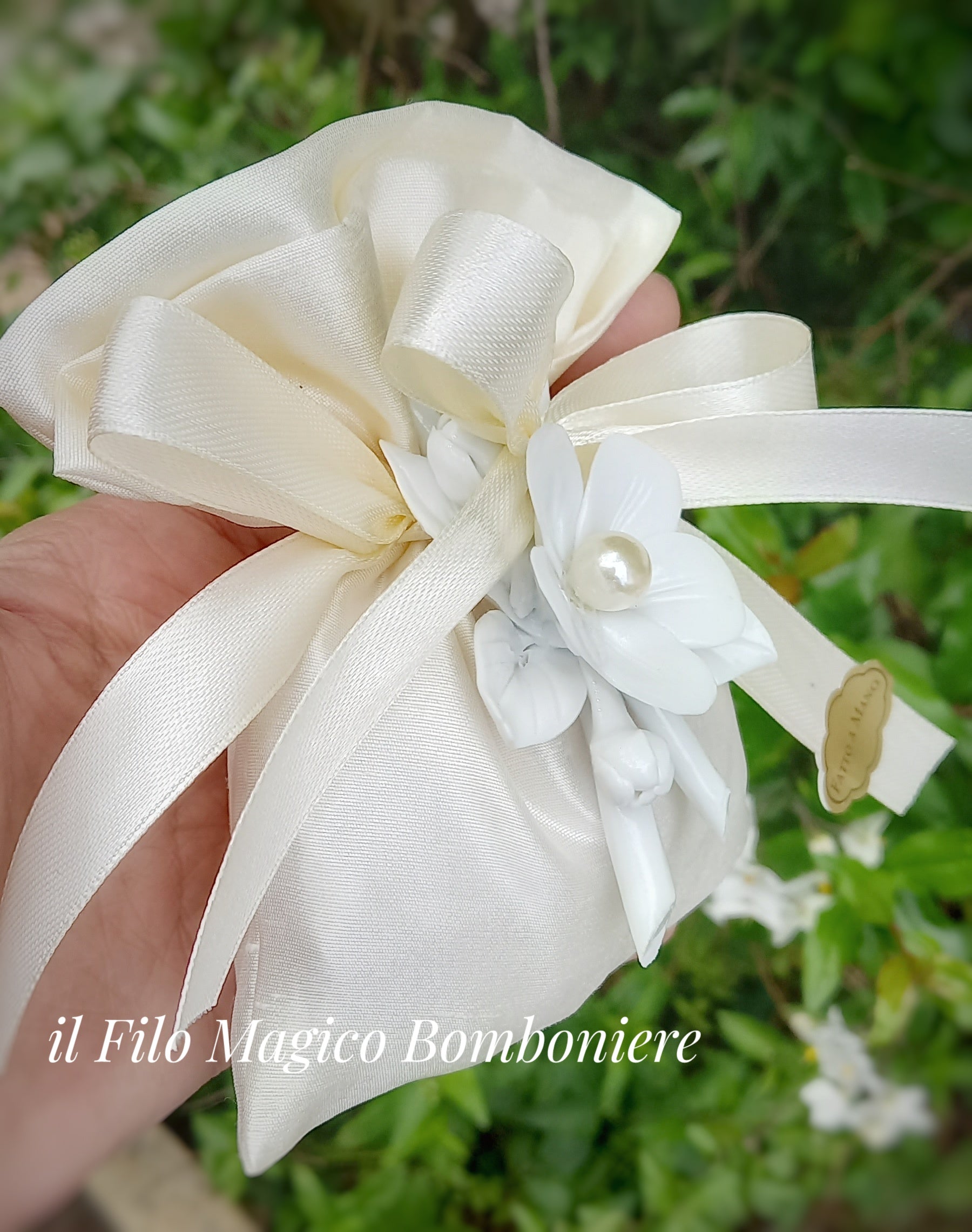 Dettaglio bomboniera con sacchetto in seta e fiore bianco decorativo