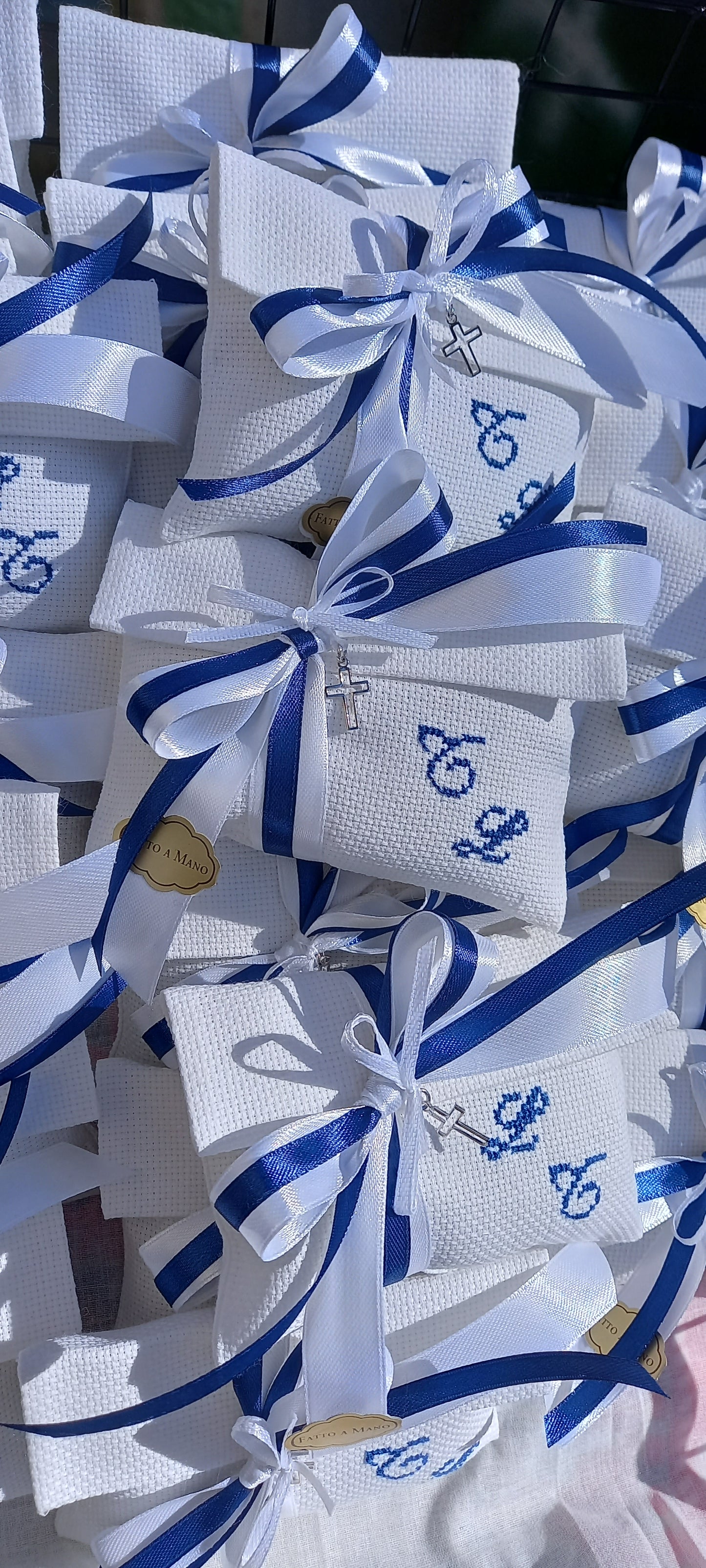 Sacchetti battesimo gemelli artigianali con ricamo personalizzato e ciondolo croce