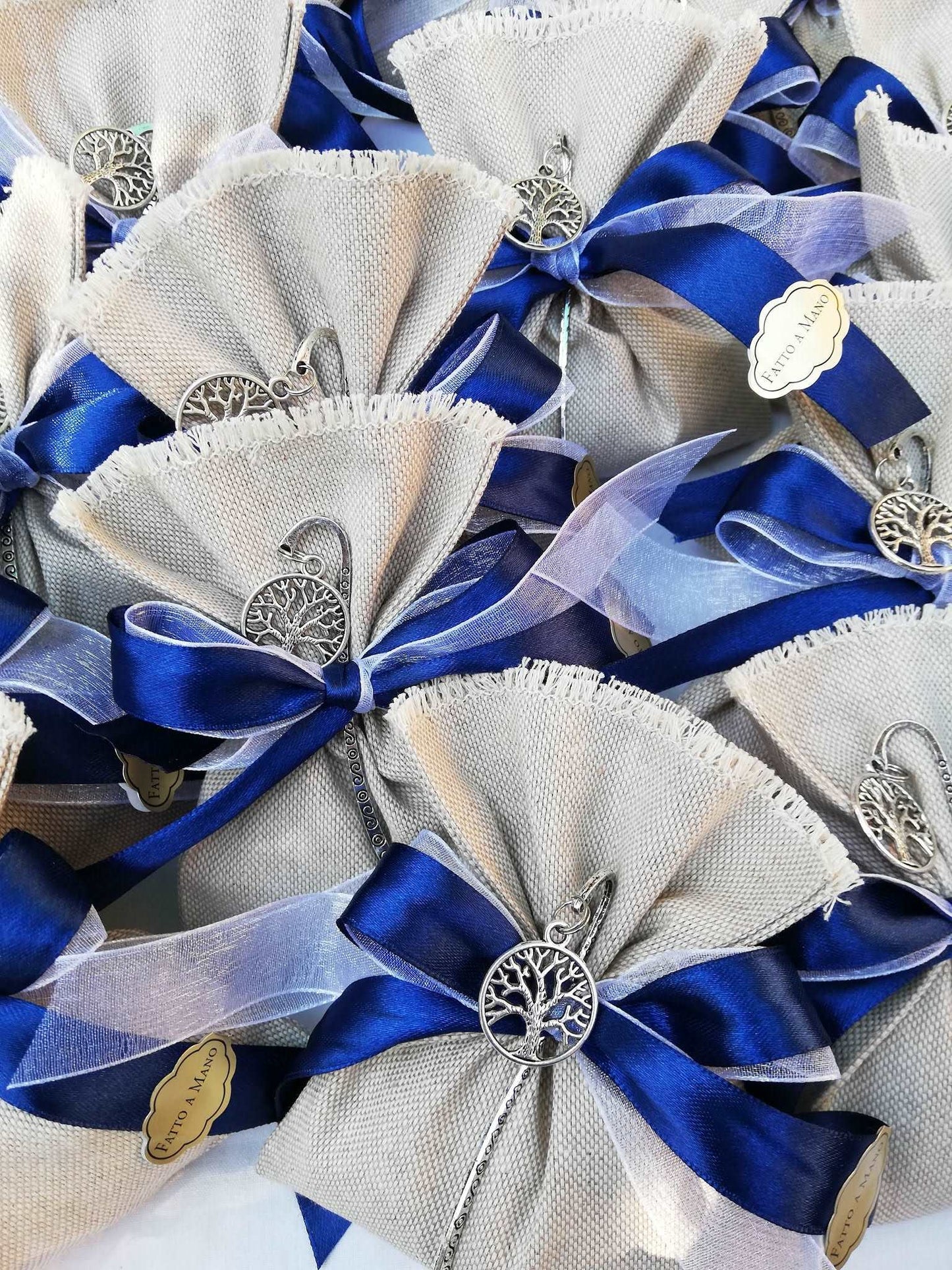 bomboniere comunione o cresima bimbo composte da sacchettino in lino grezzo nastri raso blu e organza bianco e segnalibro albero della vita argentato