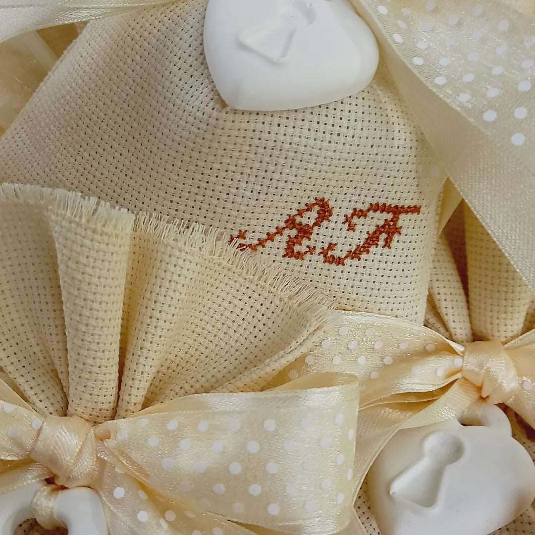 bomboniere matrimonio sacchettino avorio con iniziali dei nomi ricamate a mano in marrone nastro raso e organza a pois avorio e cuore lucchetto profuma biancheria